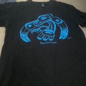 Black shirt with blue sculpture on front from Canada